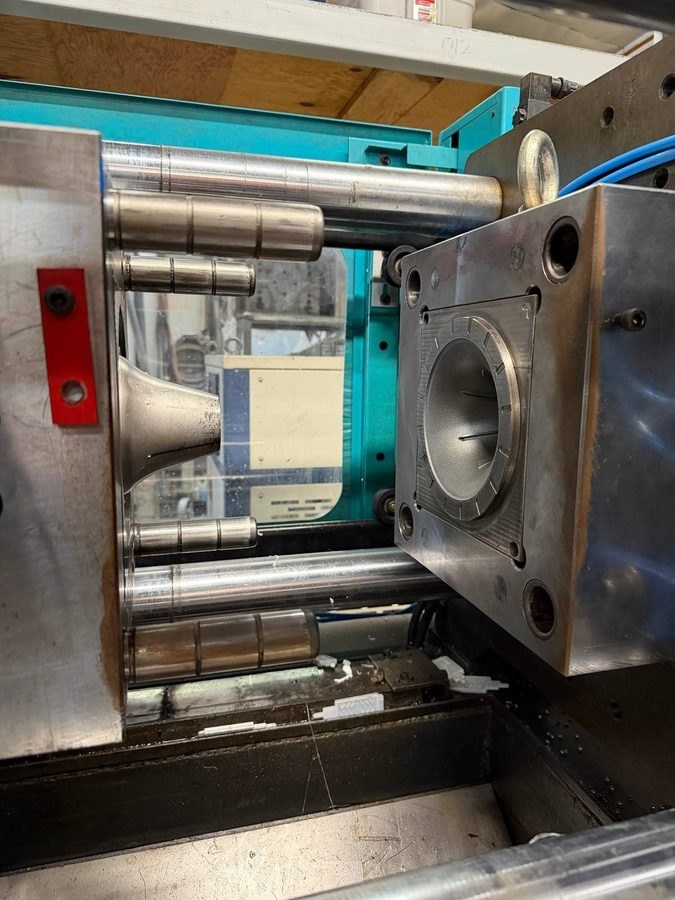The steel injection mould open in the machine.